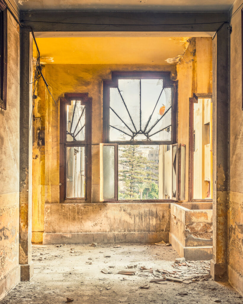 Fenêtre Art déco diffusant la lumière dans le hall d’un ancien cinéma de Tripoli en restauration.