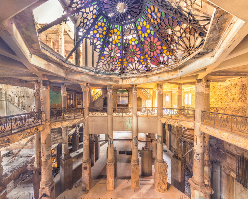 Hall circulaire du Grand Théâtre des Mille et Une Nuits éclairé par une coupole de vitraux colorés.