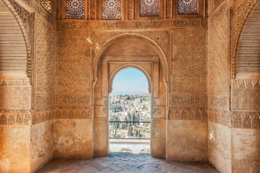 Intérieur du palais de l’Alhambra révélant les stucs sculptés et les motifs géométriques de l’art nasride.