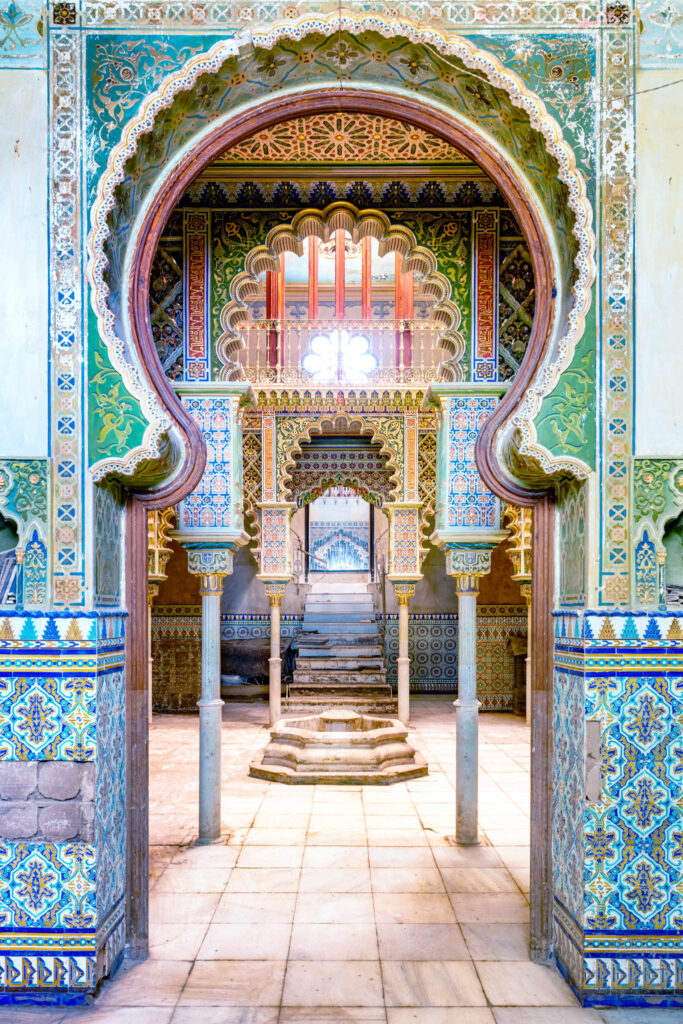 Porte ornée de céramiques et d’arcs sculptés dans une villa d’inspiration mauresque.