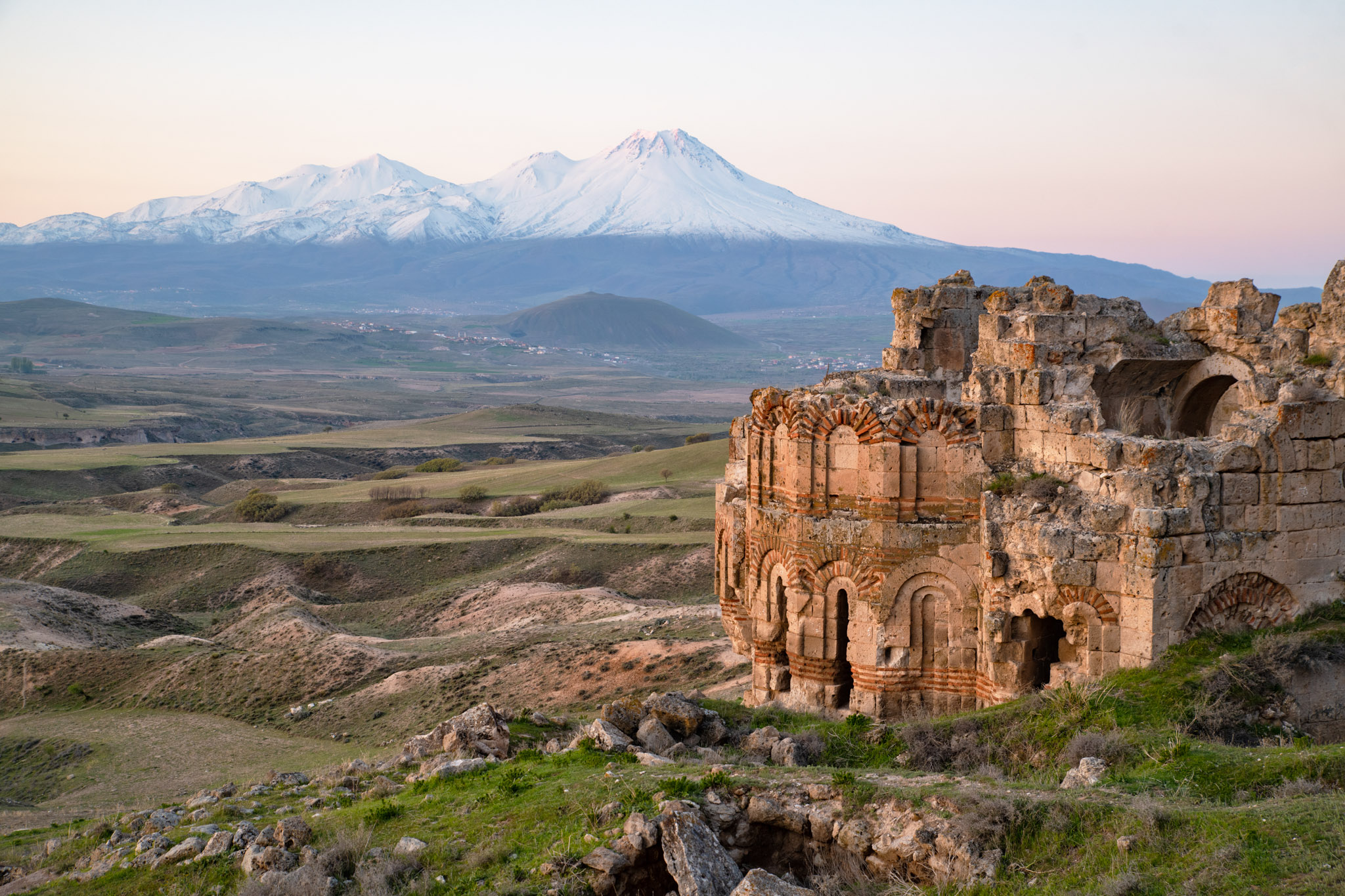 Ruines d’une église byzantine dans un paysage de plateau avec le mont Ararat enneigé au loin