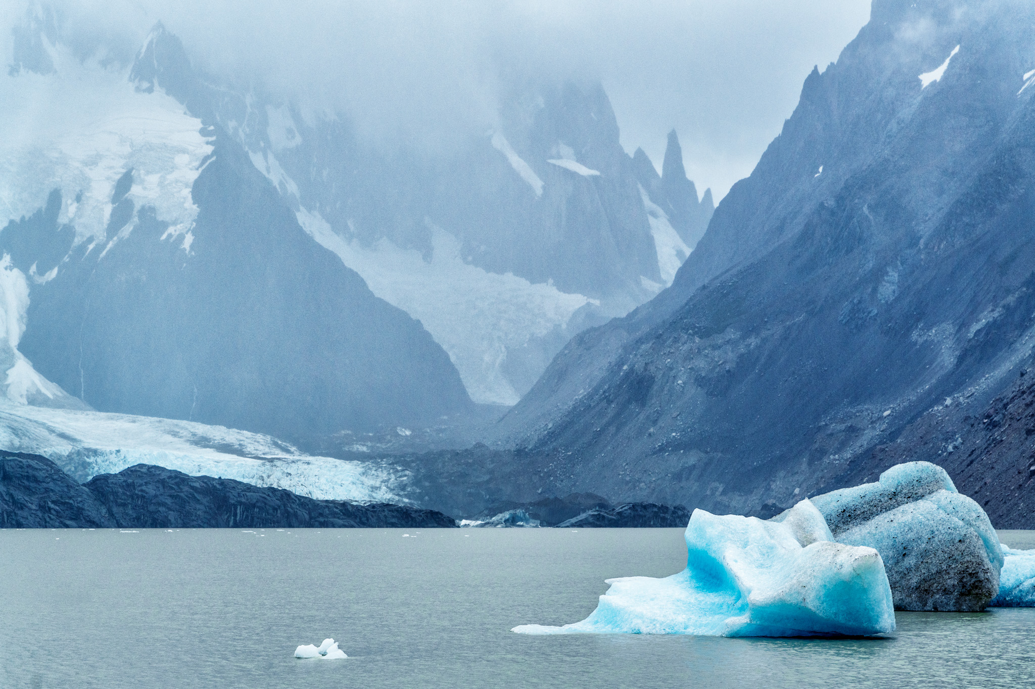 Bloc de glace bleutée flottant sur la Laguna Torre devant les montagnes de Patagonie