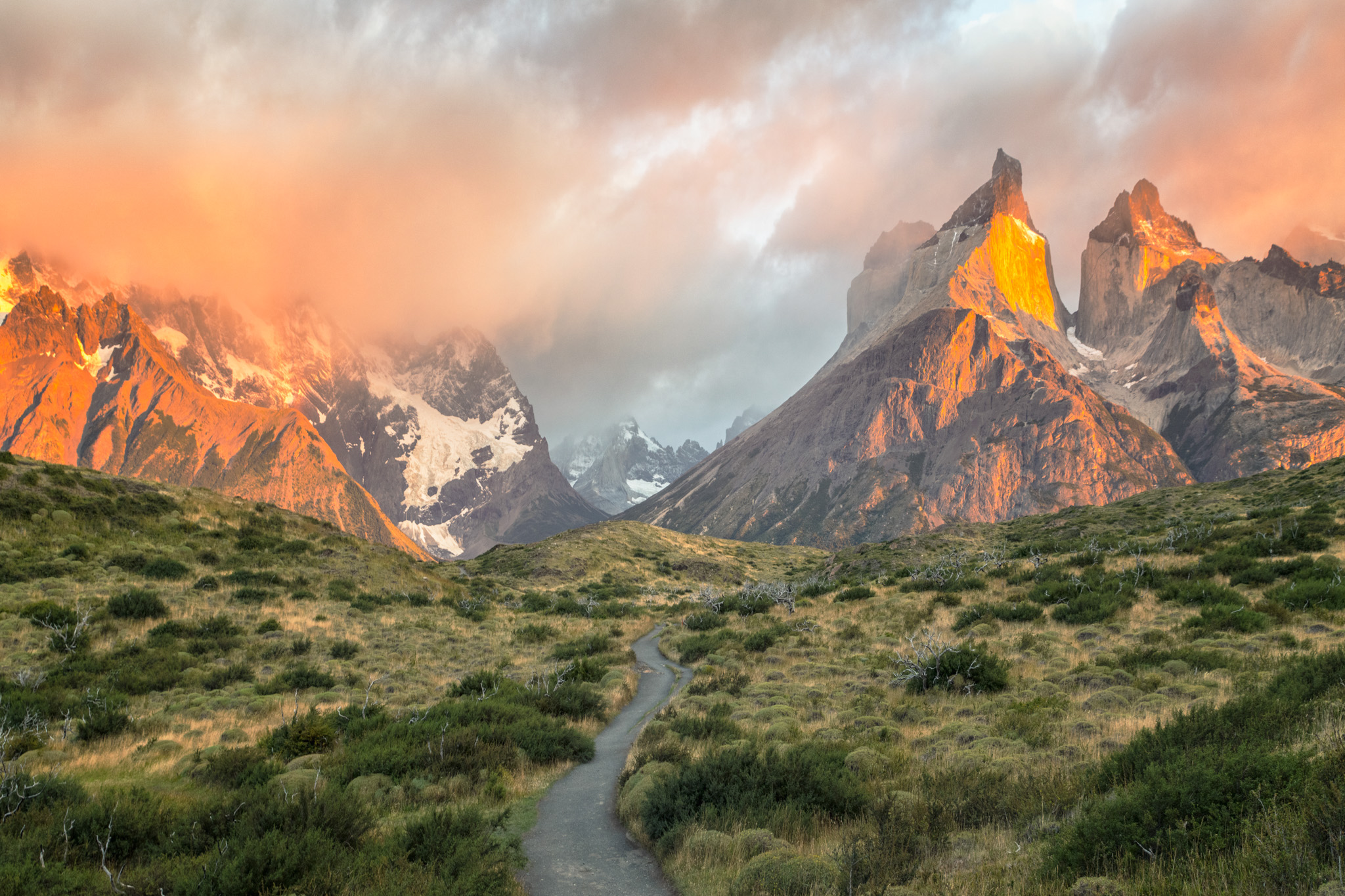 Sommets de Torres del Paine éclairés par le soleil levant au-dessus d’une vallée