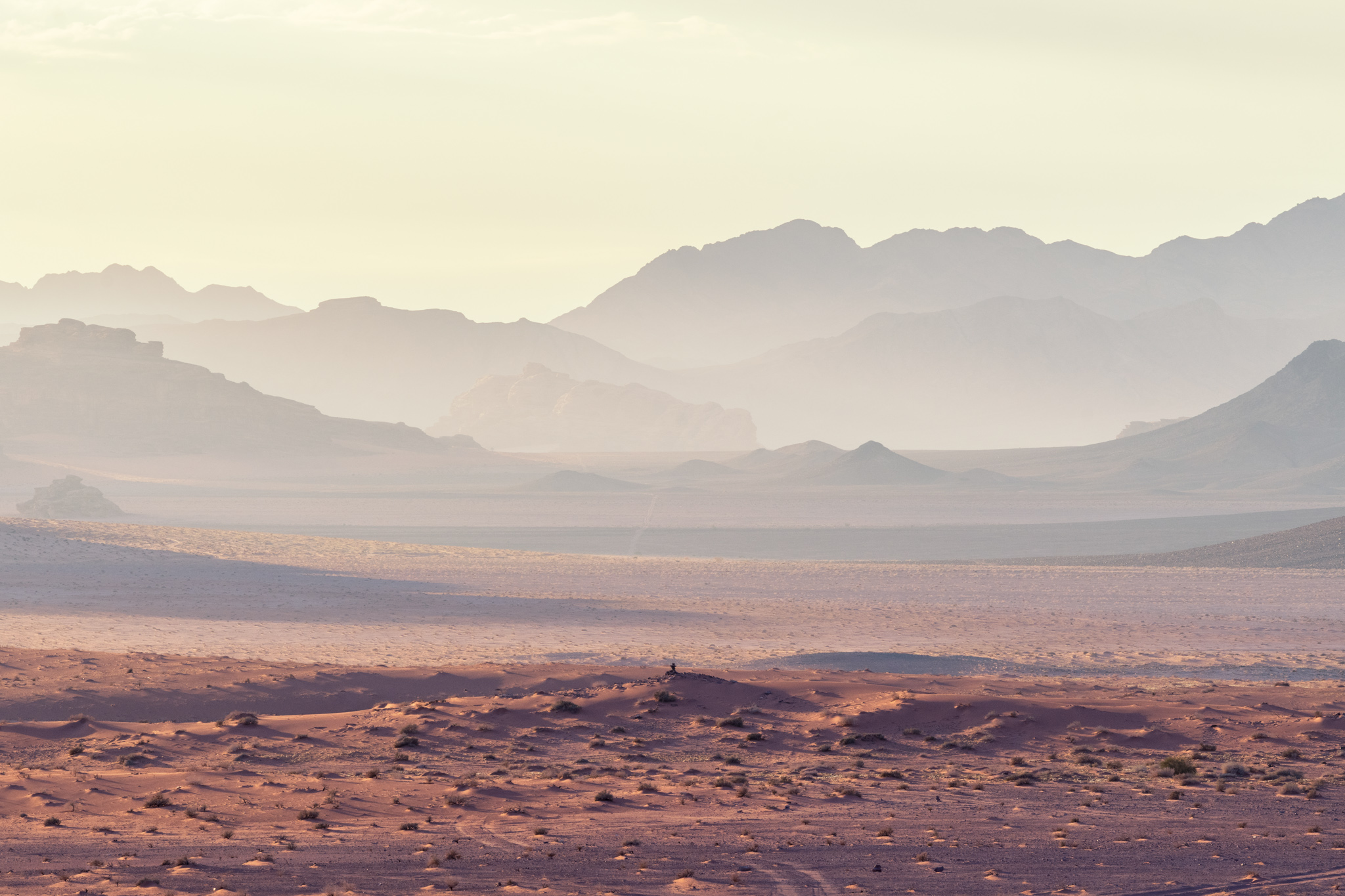Massifs du Wadi Rum apparaissant dans la lumière brumeuse du lever du soleil