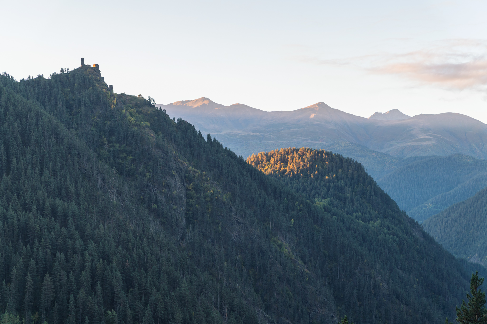 Vallée montagneuse de Touchétie avec un village fortifié dominant les pentes