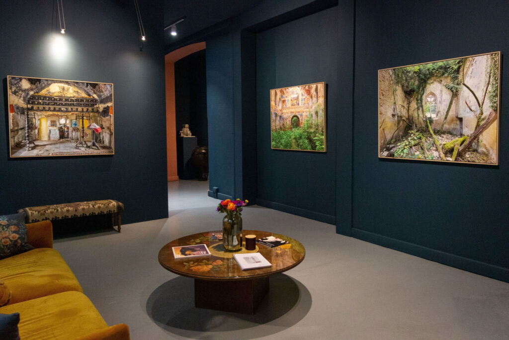 Vue intérieure de la Camilla Prini Gallery avec plusieurs photographies de la série Dogma accrochées sur des murs bleu sombre