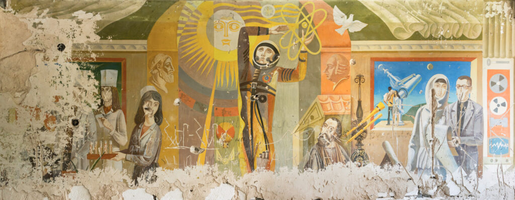 Fresque soviétique colorée dans un bâtiment abandonné du Karabagh, avec figures humaines, symboles religieux et colombe blanche.