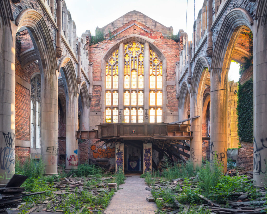 Nef sans toiture de la City Methodist Church à Gary, avec grande verrière gothique, murs de brique et végétation au sol