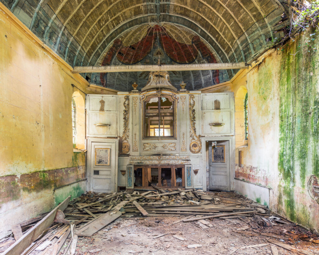Intérieur abandonné d’une église bretonne, avec voûte peinte, autel blanc, murs verdis par l’humidité