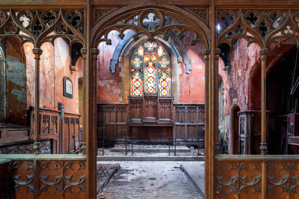 Intérieur désaffecté de l’église Saint James à Pontypool, avec clôture de chœur en bois sculpté et vitraux colorés