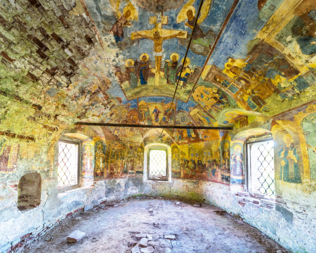 Voûte et murs peints de l’église de la Trinité de Krasnoye-Sumarokovo, avec scènes religieuses colorées entre plusieurs fenêtres