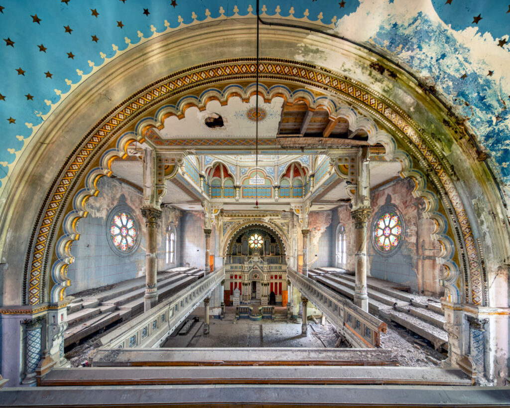 Vue intérieure de la synagogue Fabric de Timișoara, avec grand arc mauresque peint, décor polychrome et arche sainte.