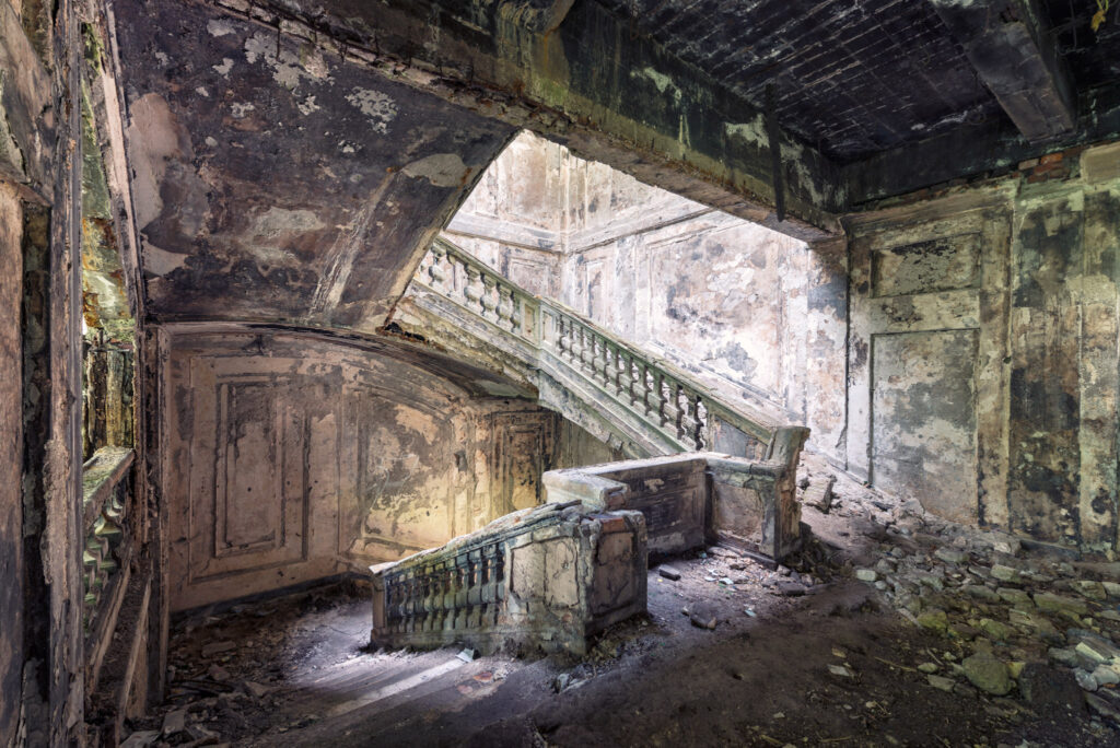 Escalier monumental en ruine de l’ancien bâtiment du Parlement géorgien à Soukhoumi, avec des rampes brisées et des murs noircis