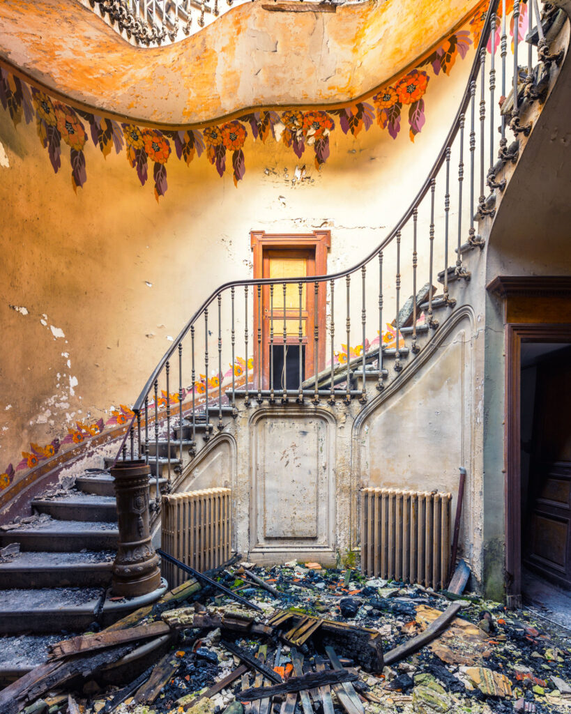Escalier Art nouveau d’une ancienne maison de directeur d’usine, éclairé par une ouverture créée après l’effondrement du plafond.