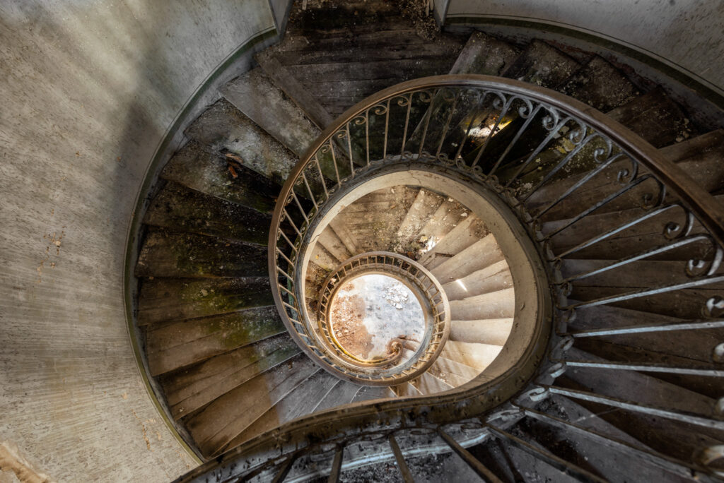 Ancien escalier principal en bois et plâtre dans une demeure d’un domaine bordelais en France.
