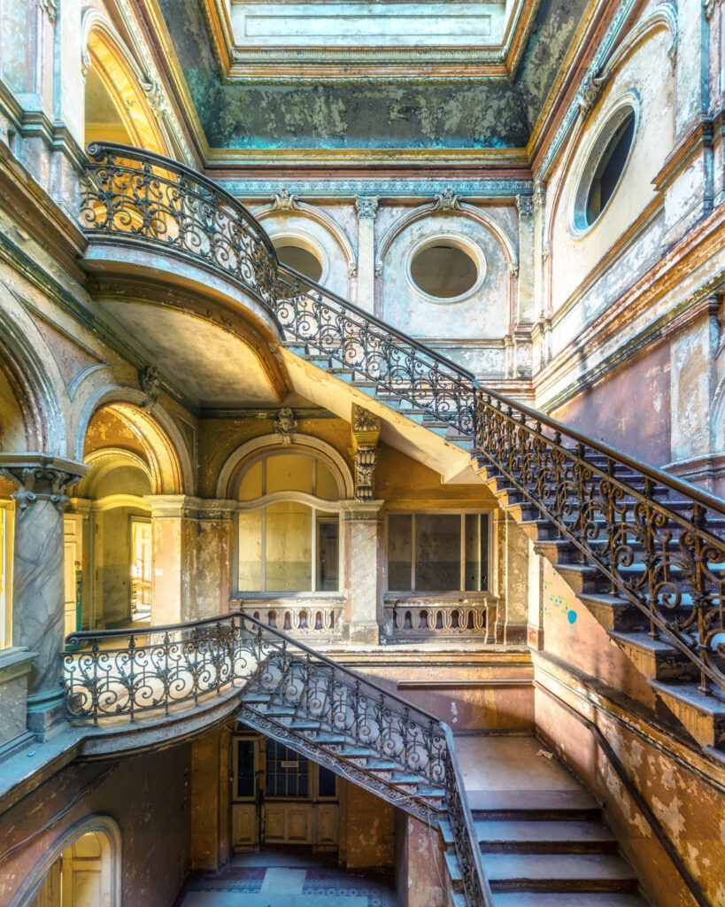 Vestibule d’honneur du Pałac Krowiarki en Pologne avec escalier monumental, décors de stuc et architecture palatiale.
