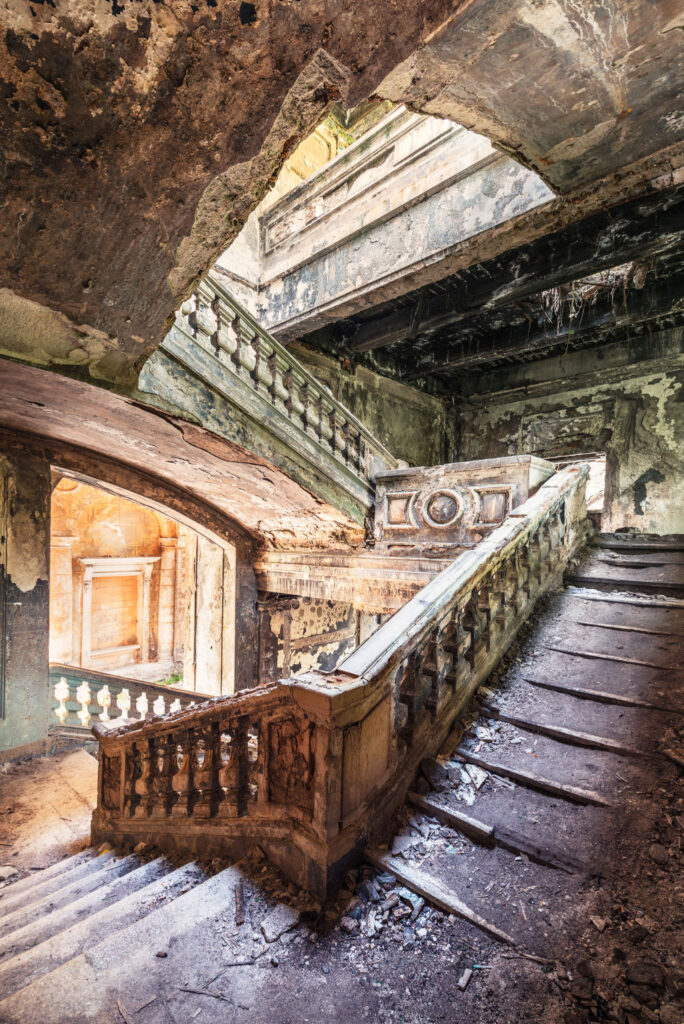 Escalier latéral néoclassique russe de l’ancien bâtiment gouvernemental géorgien en Abkhazie, marqué par les traces du conflit.