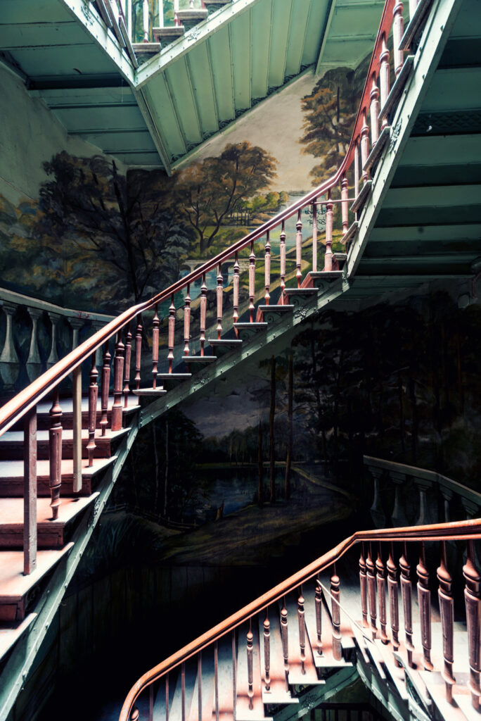 Escalier d’immeuble historique à Wrocław avec peinture murale réalisée par un habitant dans une ancienne kamienica polonaise.