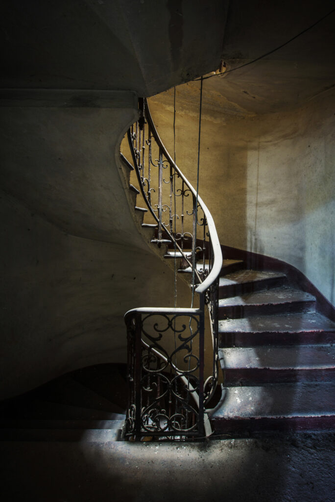Escalier secondaire de la Villa Borromeo d’Adda en Italie, éclairé par un puits de lumière central avant sa restauration.