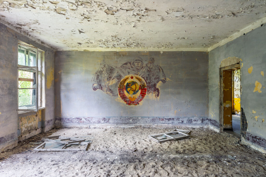 Fresque soviétique partiellement conservée dans une pièce abandonnée aux murs dégradés en Brandebourg.