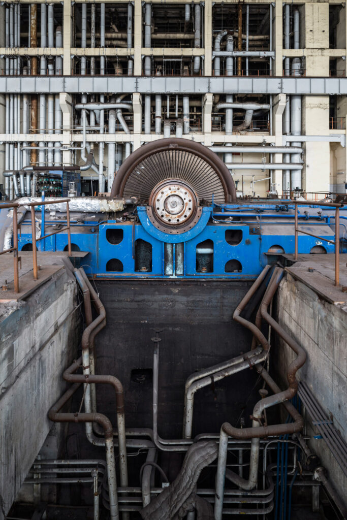 Générateur bleu et tuyauteries dans la halle d’une ancienne centrale électrique abandonnée en Saxe.