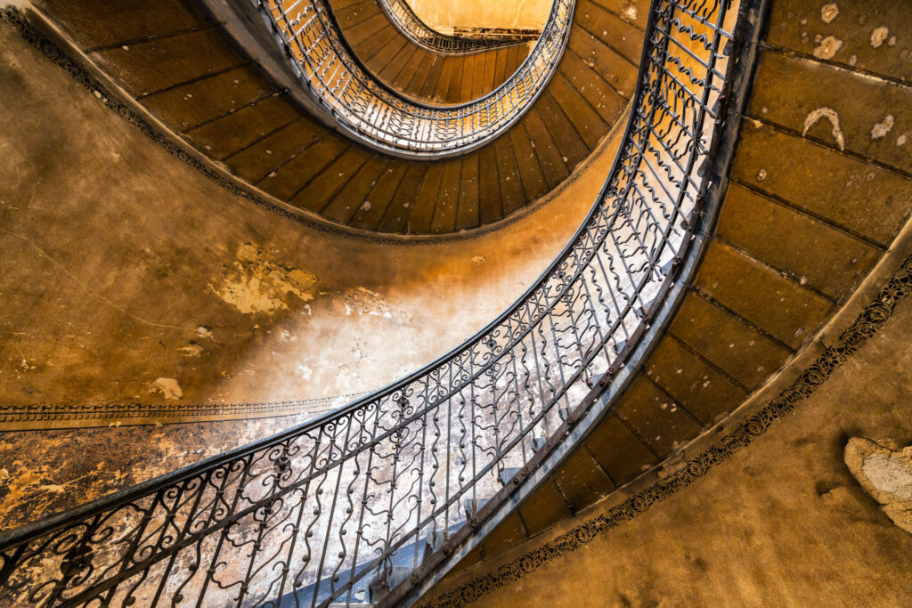 Cage d’escalier intérieure d’un immeuble historique de Budapest reliant les étages autour d’une cour centrale.