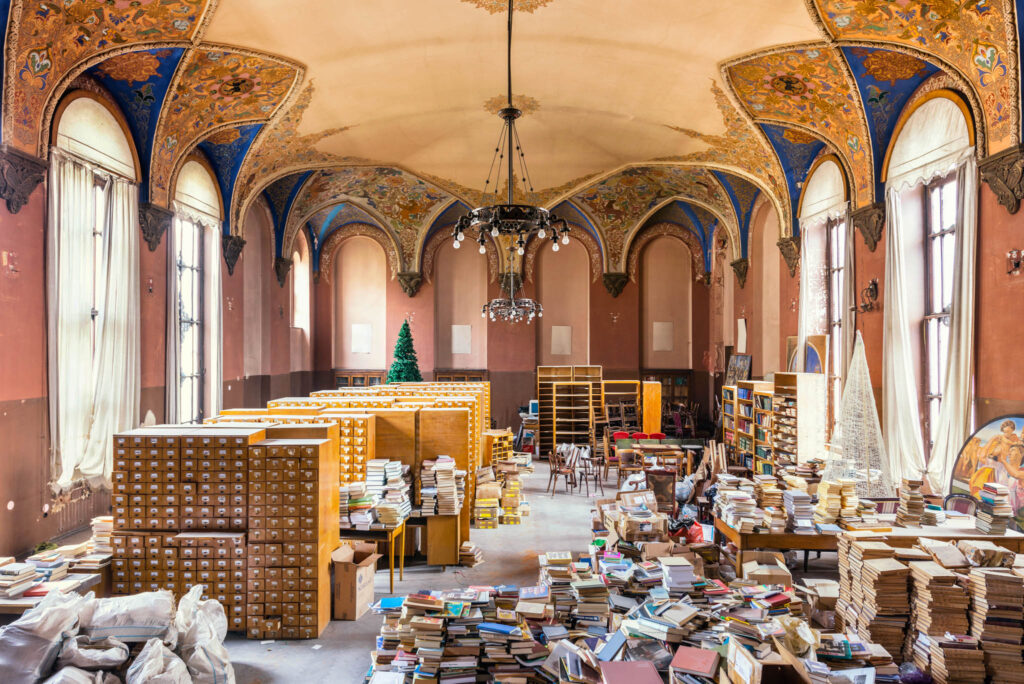 Ancienne salle de lecture de la Bibliothèque parlementaire nationale de Géorgie, avec mobilier, livres empilés et arcs peints.