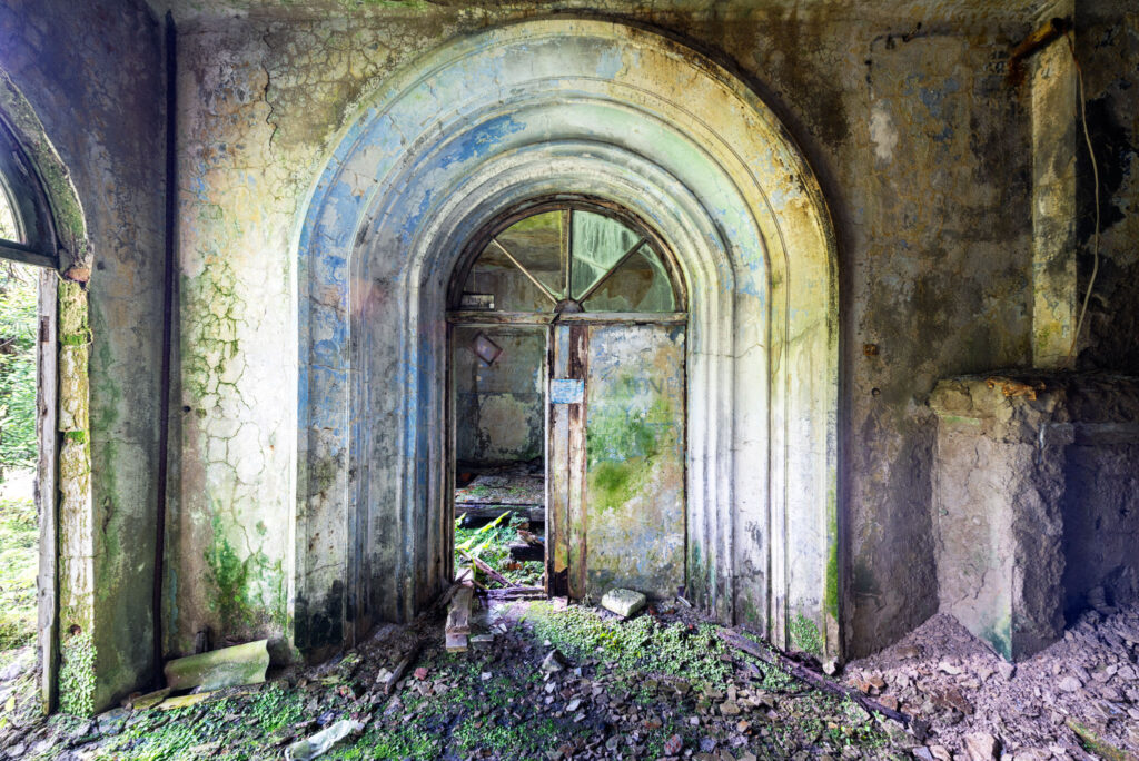 Intérieur en ruine d’une ancienne hotel au-delà de Tkvarchal, avec de grandes arches pour l'ouverture des portes principales