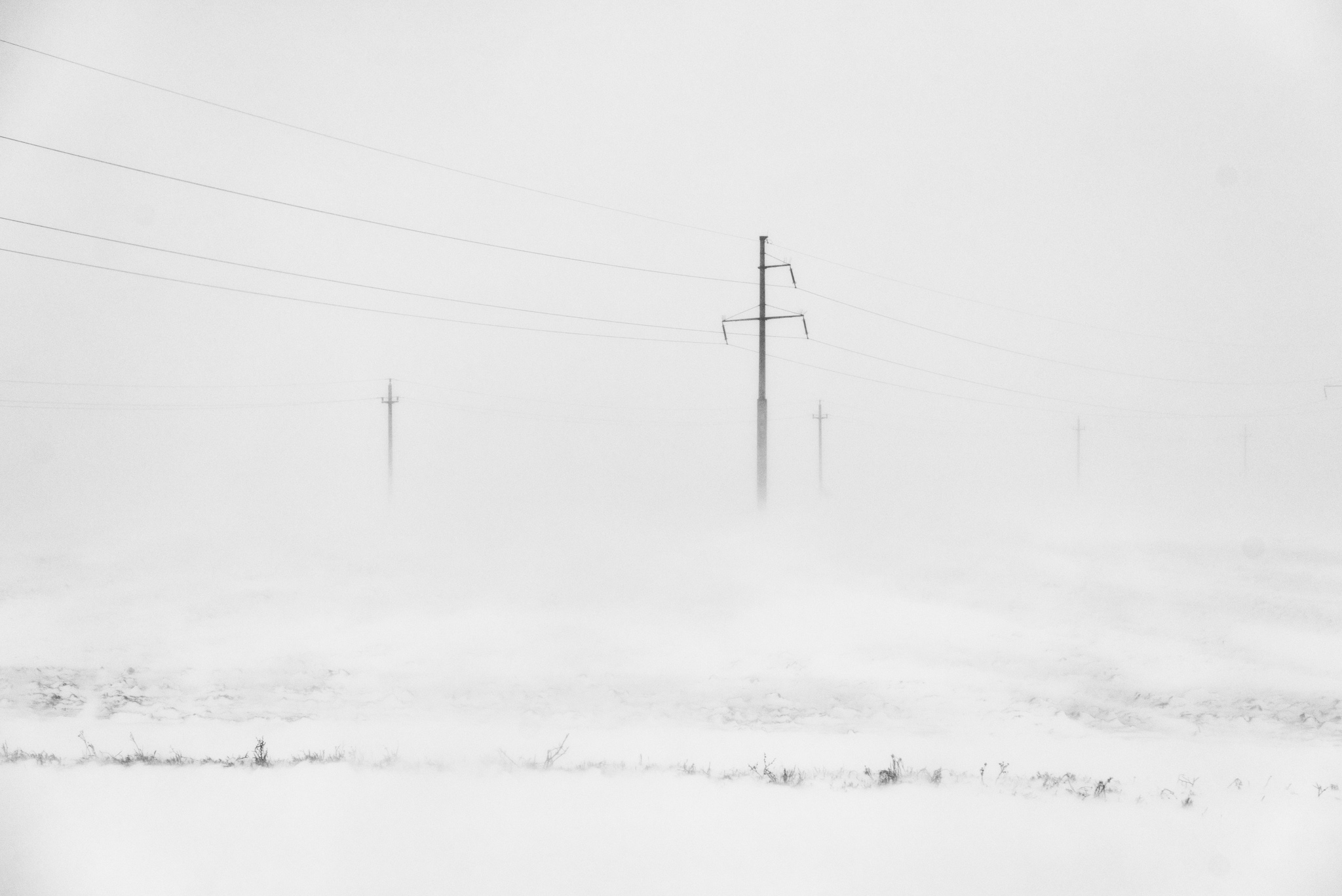 Poteaux électriques et fils à peine visibles dans un paysage enneigé de Roumanie