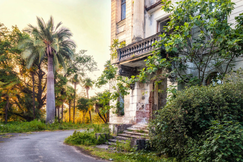 Façade du palais abandonné du prince Smetsky, entourée d’un jardin subtropical de palmiers et d’une végétation dense