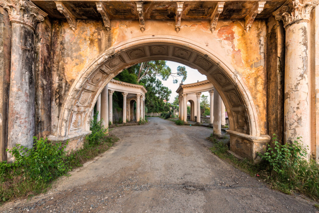 Porte monumentale abandonnée sur les hauteurs de Soukhoumi, encadrée par de grandes arches et une végétation envahissante