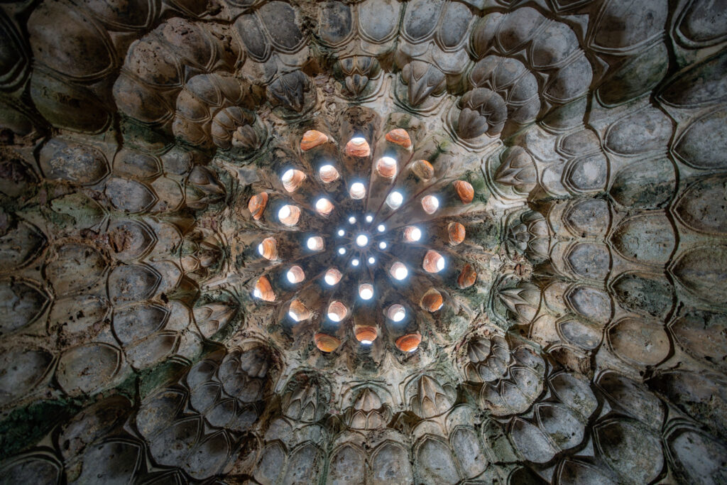 Vue verticale du plafond d’un ancien hammam turc avec coupole alvéolée et nombreux oculi vitrés laissant passer des points de lumière