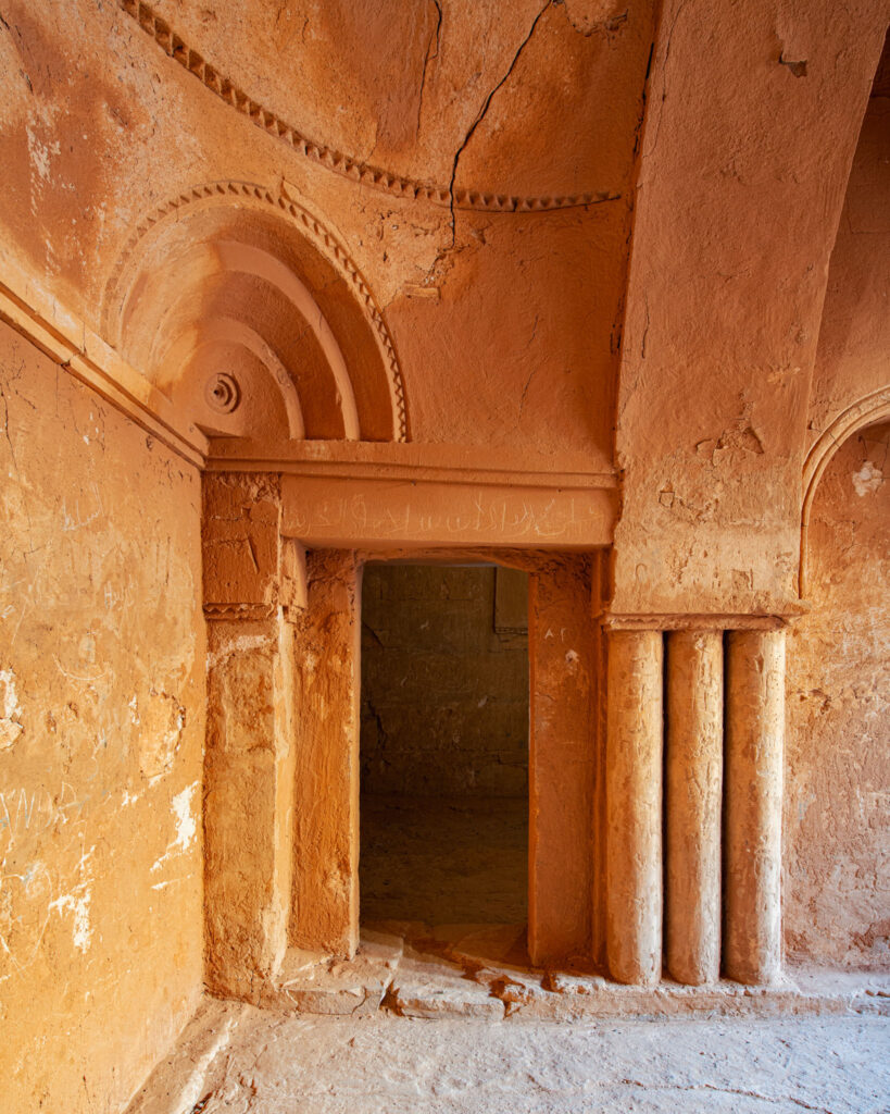 Porte encadrée de colonnettes et d’un arc décoré à l’intérieur du château du désert omeyyade de Qasr Kharana en Jordanie